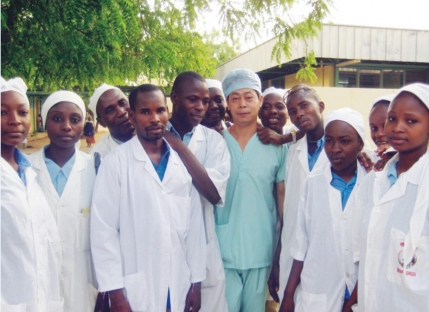 外科医师曾光援外时与当地医护人员合影